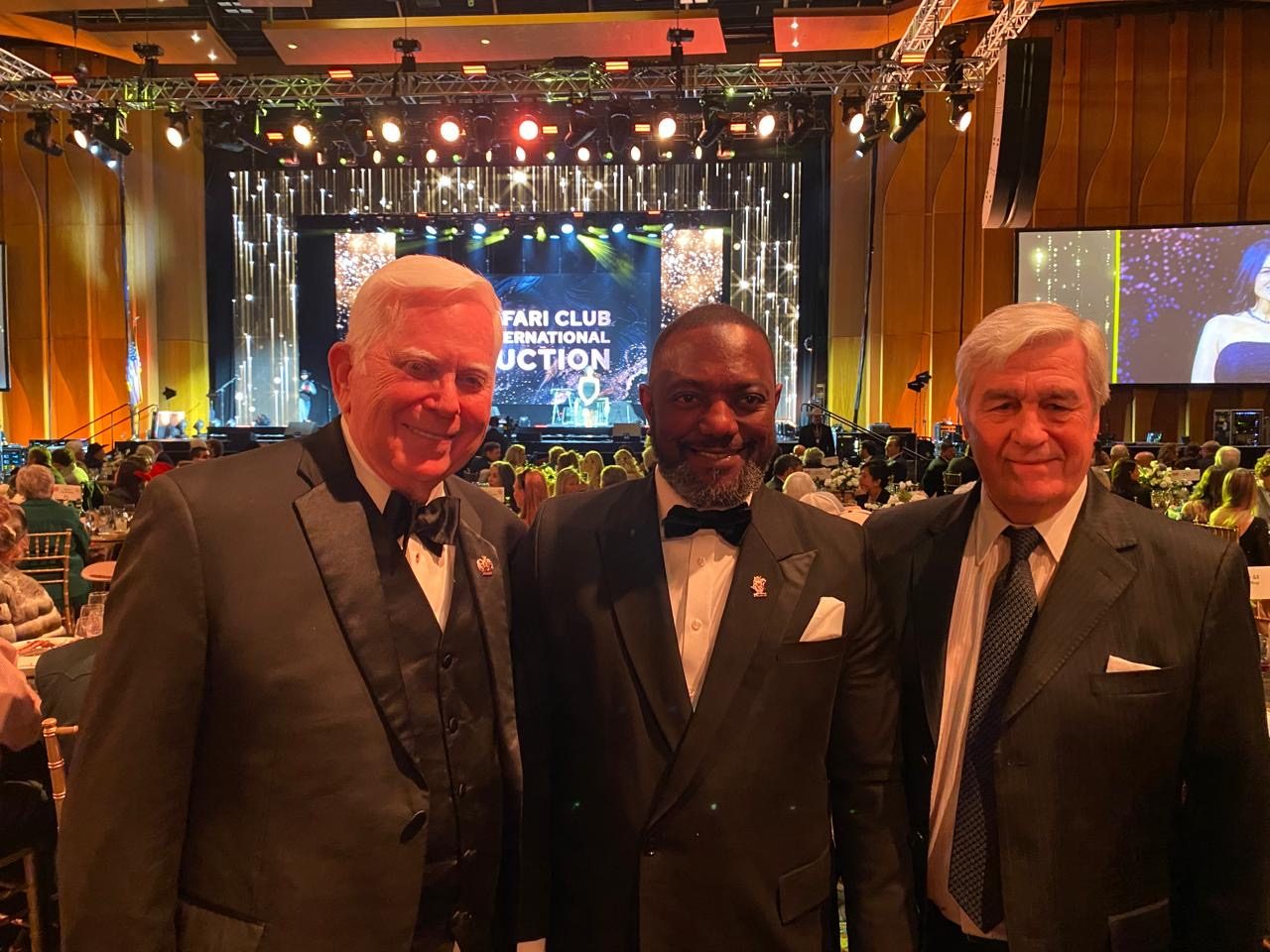 Three men in black tie at the SCI auction dinner